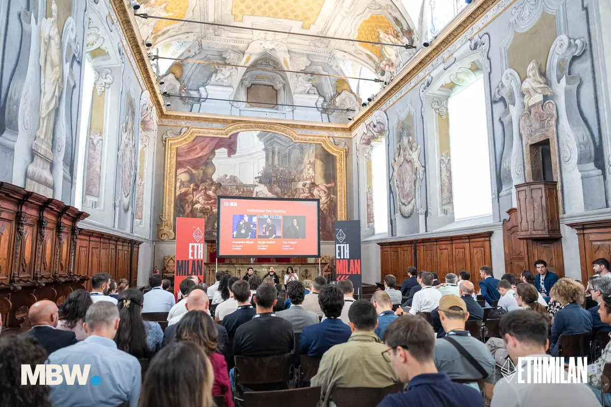 A talk on the ETHMilan main stage under the frescoed ceiling, the room full